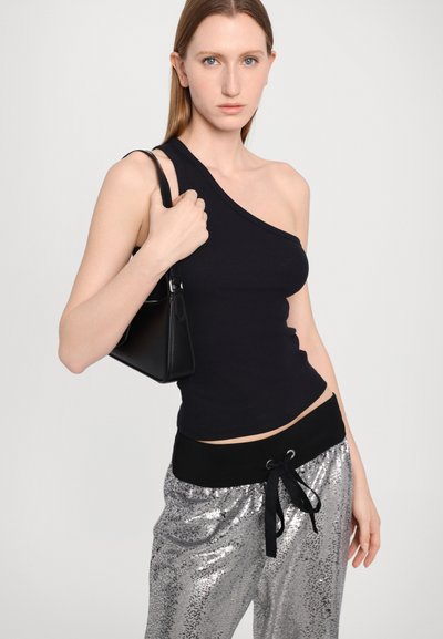 Zwarte een-schouder ribbed tanktop, gecombineerd met glanzende zilveren pailletten joggers met een zwarte trekband in de taille. Zwart handtasje inbegrepen.