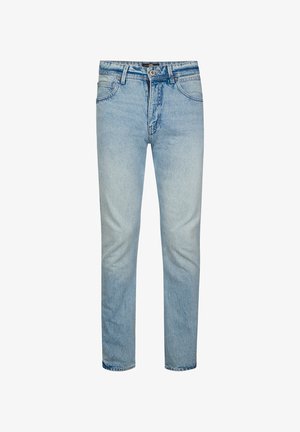 Lichtblauwe spijkerbroek met een bruine leren label op de taille met de tekst "Petrol, Denim Driven Since 1989, Crafting Quality Garments".