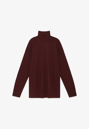 Pull à col roulé bordeaux en tissu tricoté doux, avec une coupe ample, des épaules tombantes, et des poignets et ourlet côtelés.