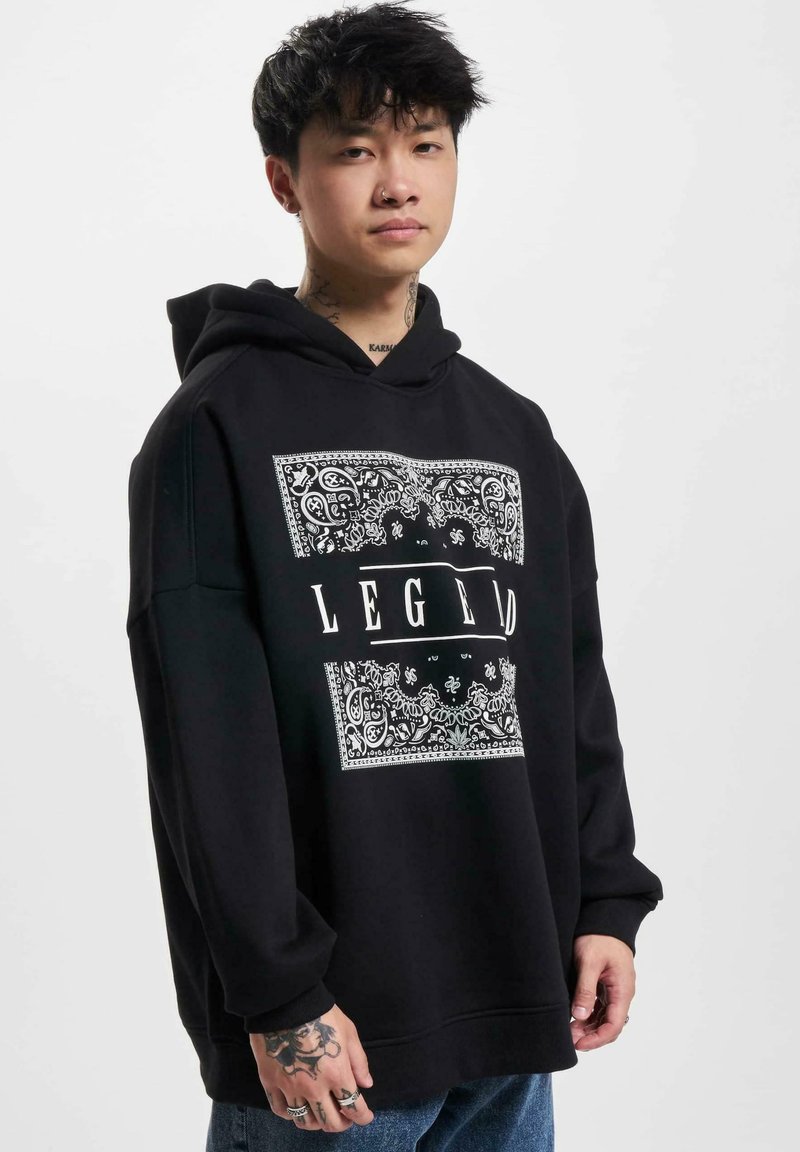 Black oversized hoodie made of cotton, featuring a white paisley pattern and the word "LEGEND" in bold lettering across the front.