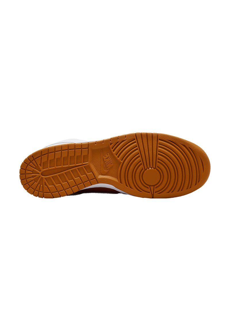 Semelle de sneaker Nike avec une semelle en caoutchouc naturel, présentant un motif texturé de lignes circulaires et verticales, principalement de couleur orange.