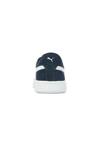 Sneaker in suede blu navy con dettagli bianchi, punta rotonda e suola texturizzata. Logo Puma sulla parte posteriore e laterale per il branding.