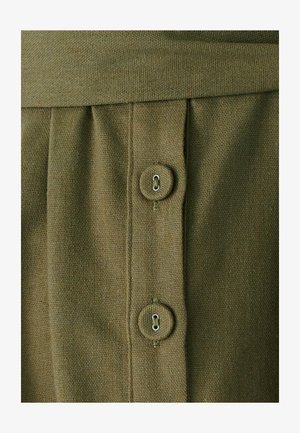 Olive green, textured fabric with a pleated design. Features two round buttons with metal loops. Simple, functional detailing.