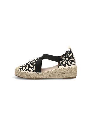 Sandalia de cuña tipo espadrille con diseño floral troquelado en negro sobre tela color crema, tiras elásticas cruzadas y suela de yute trenzado.