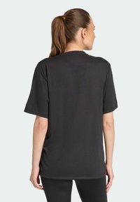 Sort bomulds t-shirt med en afslappet pasform, korte ærmer og et rent bagside design. Minimalistisk stil uden synlige grafik eller logoer.