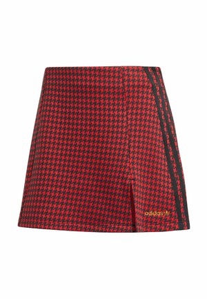 Red and black houndstooth shorts with a fitted design, featuring black side stripes and a gold logo accent. Textured fabric.