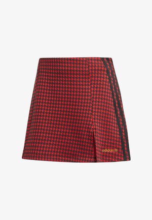 Shorts à motif pied-de-poule rouge et noir avec une coupe ajustée, présentant des rayures latérales noires et un accent de logo doré. Tissu texturé.
