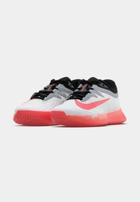 Sapatos atléticos leves com um cabedal branco, detalhes em rosa e um padrão cinza texturizado. Apresenta um fecho com atacadores pretos e sola de borracha.