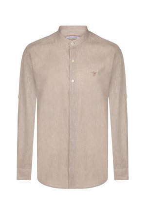 Chemise beige clair à manches longues avec col mandarin, boutons sur le devant et un petit logo d'oiseau brodé sur la poitrine. Tissu texturé.