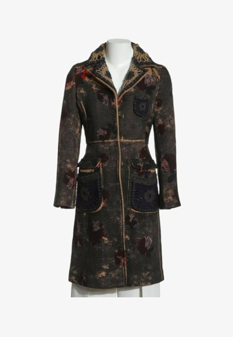 Manteau long à motif floral foncé avec col cranté, poches plaquées devant et bordure contrastante sur un buste de mannequin blanc.