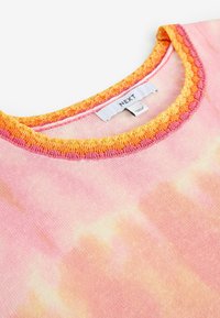Rosa und orangefarbener Batik-Pullover mit einem strukturierten orangen, gewellten Halsausschnitt und einem Etikett mit der Aufschrift "NEXT". Weiches Baumwollmaterial, lässiges Design.