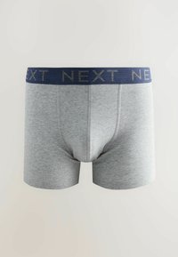 Grå bomullsboxer med en marinblå midja som visar ordet "NEXT" i metallisk lettering. Klassisk design med kort ben, utan tydliga mönster.