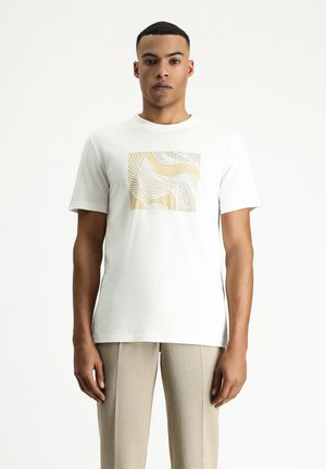 Camiseta de algodón blanca con un gráfico cuadrado en dorado claro y líneas blancas onduladas. Textura suave y corte relajado. Fondo neutro.