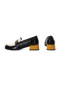 Czarno-kremowe lakierowane buty typu loafers z zaokrąglonym noskiem, z akcentem w złotym kolorze i masywnym żółtym obcasem.