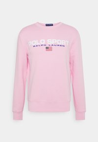 Sudadera de manga larga color rosa claro con el texto "POLO SPORT RALPH LAUREN" y una pequeña bandera americana en el pecho.