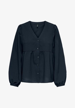 Tumši zilas blūzes ar V formas kakla izgriezumu, pogu priekšpusi un savelkamu jostu. Ar garām, pūtīgām piedurknēm un piegulošām aprocēm. Gluda, viegla auduma.