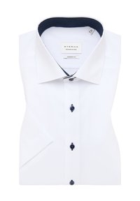 Camicia bianca a maniche corte con un taglio moderno, caratterizzata da una rifinitura interna della colletto a pois blu navy, bottoni neri e etichetta del brand inclusa.