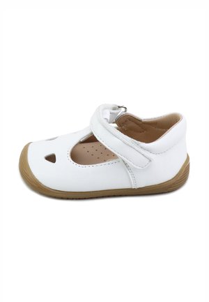 Zapato para niño pequeño blanco con suela marrón, cierre ajustable de Velcro y orificios de ventilación recortados en el área de los dedos.