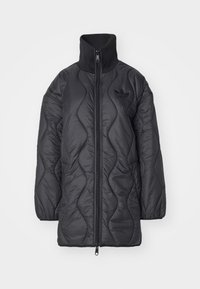 Chaqueta acolchada negra con cuello alto, cremallera frontal completa y logo tonal. Presenta ondas texturizadas y mangas largas. Material ligero.