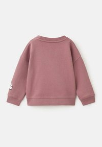 Felpa rosa con colletto rotondo e spalle scese. Presenta polsini e orlo a coste, e un tessuto testurizzato. Nessun design visibile sulla parte anteriore.