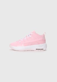 Zapatillas deportivas de color rosa claro con una textura suave, presentan cordones blancos, paneles perforados a los lados y una suela acolchada.