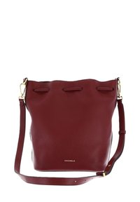 Borsa a secchiello in pelle bordeaux con design semplice, ferrature color oro, tracolla regolabile e chiusura superiore con coulisse. Logo stampato sul davanti.