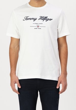 Weißes Baumwoll-T-Shirt mit schwarzem "Tommy Hilfiger"-Logo, darunter in Blau und Rot die Aufschrift "Established 1985" und "New York".