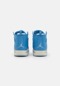 Siniset nahkakengät, joissa on valkoisia yksityiskohtia, korkealla varrella, pehmeä sisustus ja Air Jordan -logo takana.