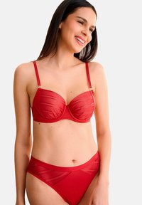 Ensemble de lingerie deux pièces rouge avec un soutien-gorge structuré à rayures transparentes et des bretelles réglables, complété par un string taille haute.