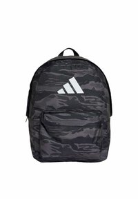 Mochila de camuflaje negra con tirantes ajustables, un asa en la parte superior y un gran bolsillo frontal. Logo de Adidas en blanco prominente en la parte delantera.