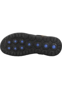 Suela de zapato con un material de goma negra, patrones de tracción circulares y acentos circulares azules. Diseñada para ofrecer tracción y durabilidad.