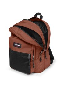 Brązowy plecak z czarnymi akcentami, posiadający dwie kieszenie zapinane na zamek, teksturowaną przednią kieszeń oraz regulowane, wyściełane szelki na ramiona.
