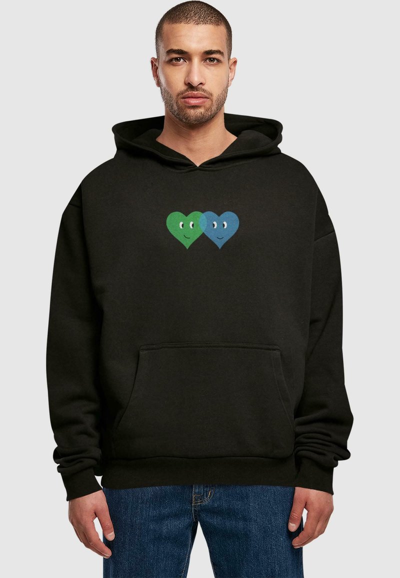 Felpa nera con cappuccio, presenta una grafica centrale di due cuori, una verde e una blu, entrambe con volti sorridenti. Tessuto morbido, tasca a marsupio.