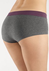 Graue Baumwollmischungshorts mit einem lila Bund, die eine weiche Textur und ein figurschmeichelndes Design aufweisen. Keine sichtbaren Muster oder Beschläge.