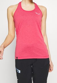 Canotta sportiva rosa con scollo rotondo, design a schiena a racer e piccolo logo bianco sul petto. Il tessuto sembra leggero e traspirante.