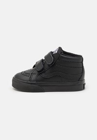Zwarte hoge peutersneaker met dubbele klittenbandsluitingen, gestructureerde rubberen zool en gestikte details op de gladde leren bovenkant.