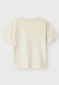 Camiseta de manga corta color beige claro, hecha de algodón suave, con un sencillo cuello redondo y un corte recto sin estampados ni adornos.