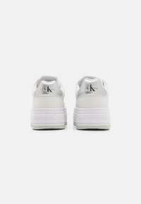 Sneakers platform bianche con tomaia in pelle liscia, dettagli in argento sul tallone e logo "Calvin Klein Jeans" stampato sulla suola.