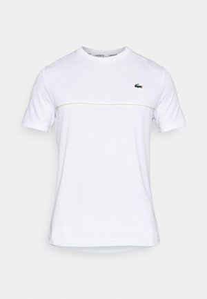 Wit katoenen T-shirt met korte mouwen, voorzien van een groen Lacoste-logo en een dunne gele horizontale streep over de borst.