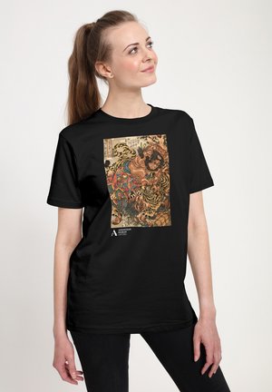 T-shirt noir avec une illustration colorée représentant une silhouette et des tigres, ornée de motifs et textures complexes, sur le devant.