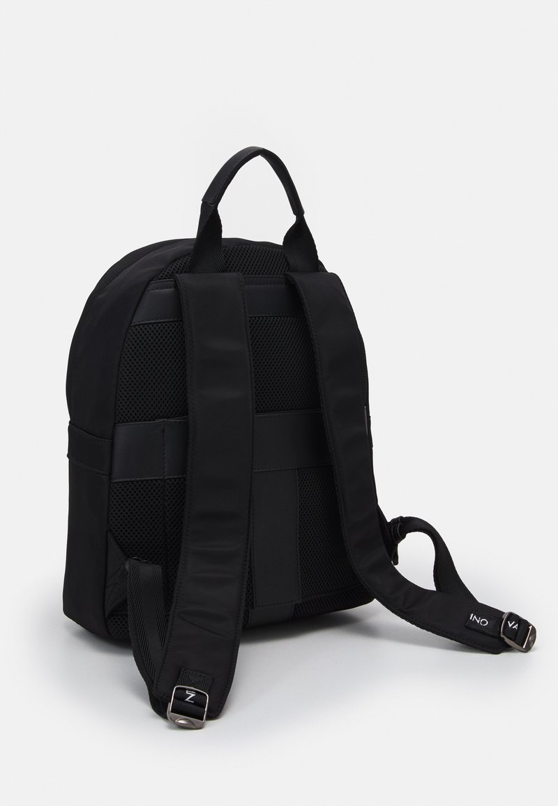 Mochila negra con un exterior liso y paneles de malla texturizada. Tiene correas acolchadas, un asa en la parte superior y una forma elegante y redondeada.