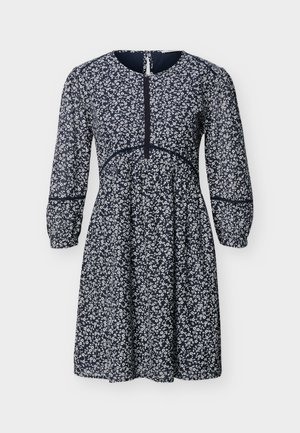 Robe bleu marine avec petit motif floral blanc, manches longues bouffantes, encolure ronde et couture de taille ajustée.