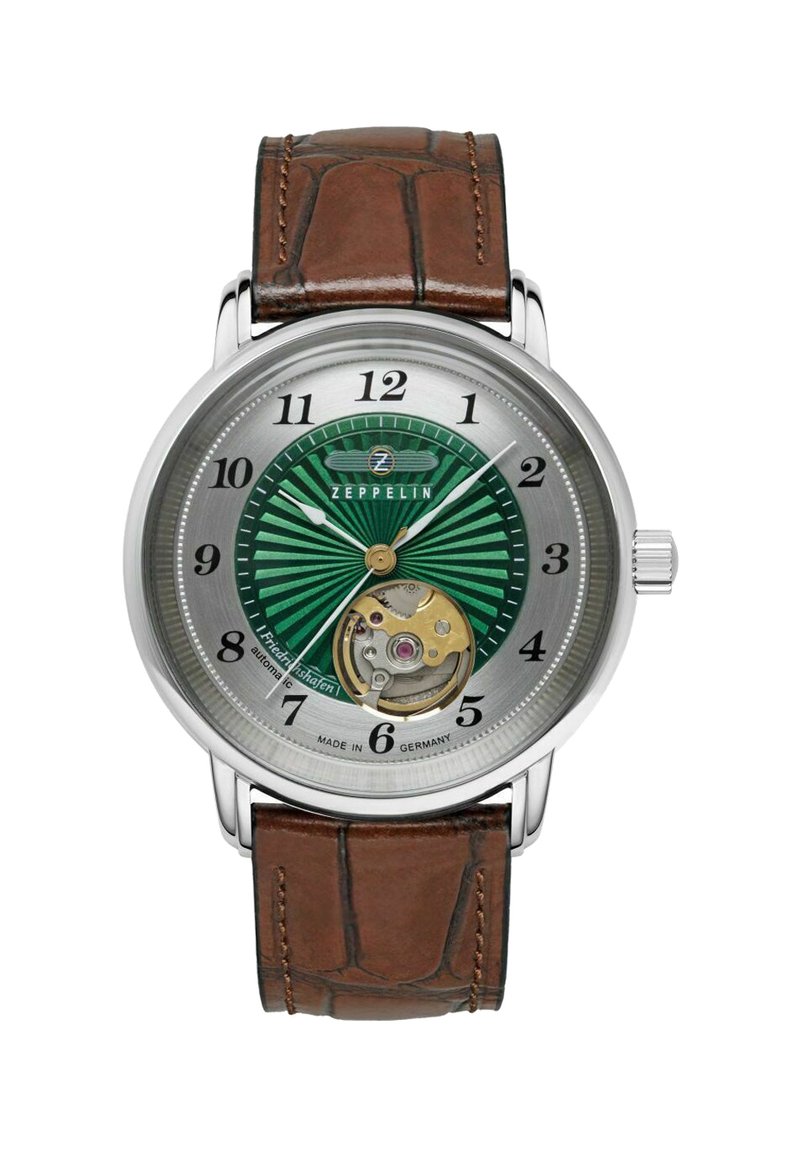 Automatic watch with a green striped dial, silver case, brown leather strap, and visible movement at the bottom. Brand logo at 12 o'clock.