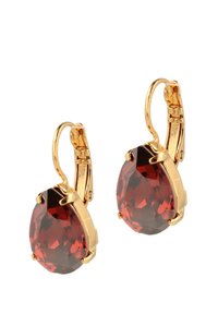 Gouden leverback oorbellen met grote peervormige rode edelstenen die facetten tonen voor een reflecterende glans.