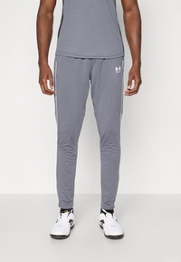 Grå treningsbukser med slim fit, med hvite sidestreker og Under Armour-logo på venstre lår. Laget av jevnt, elastisk materiale.