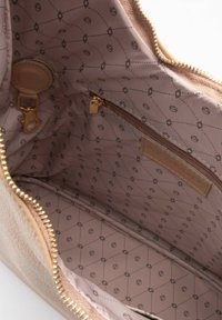 Interno in finta pelle marrone di una borsa con hardware dorato, dotato di una tasca con zip e un rivestimento beige testurizzato con motivi geometrici.