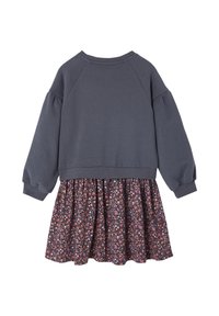 Grauer Sweatshirt mit puffärmel, verbunden mit einem Rock im floralen Muster in dunklen Tönen mit rosa und orangefarbenen Blumen, was einen geschichteten Look kreiert.
