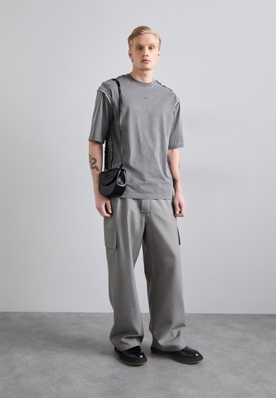 Gray cotton t-shirt with short sleeves, paired with gray wide-leg cargo pants featuring side pockets. Black shoulder bag and shoes visible.