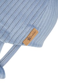 Light blue ribbed knit fabric with a small tan leather tag stitched on, featuring a star and cursive text.