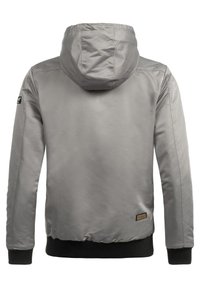 Gray hooded jacket with a smooth, shiny texture. Ribbed black cuffs and hem, featuring a logo patch on the left shoulder. Simple design.